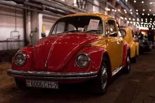 A vintage red and yellow Volkswagen Beetle displayed indoors